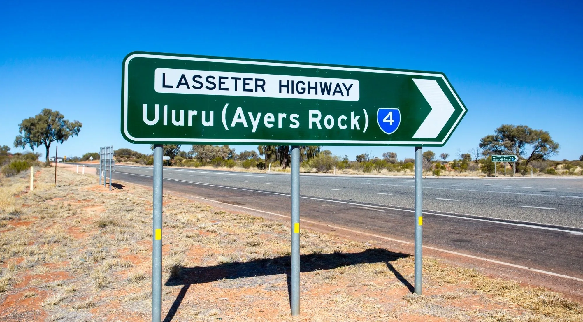 Lasseter Highway road sign pointing to Uluru (Ayers Rock)
